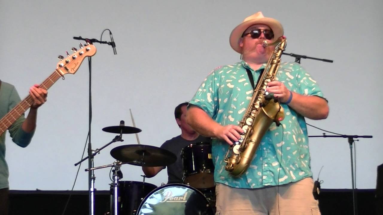 Steve Wilson playing baritone saxophone on an outdoor stage