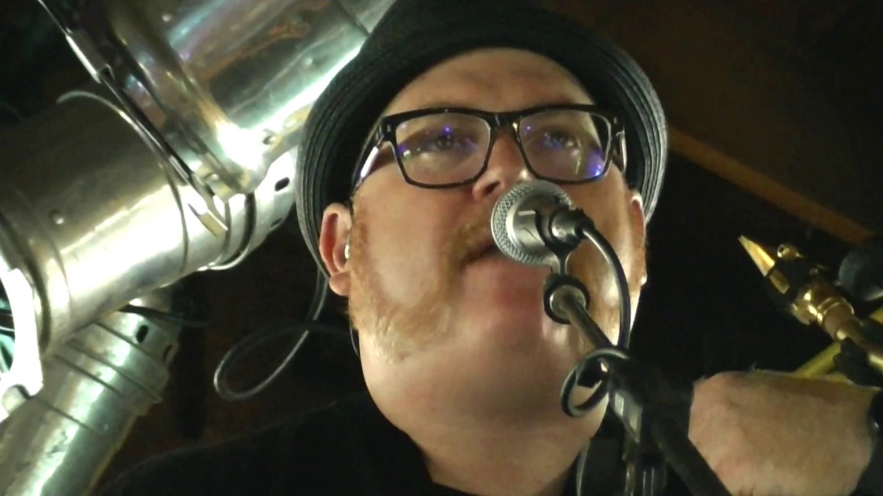 Steve Wilson at the microphone on stage with his saxophone