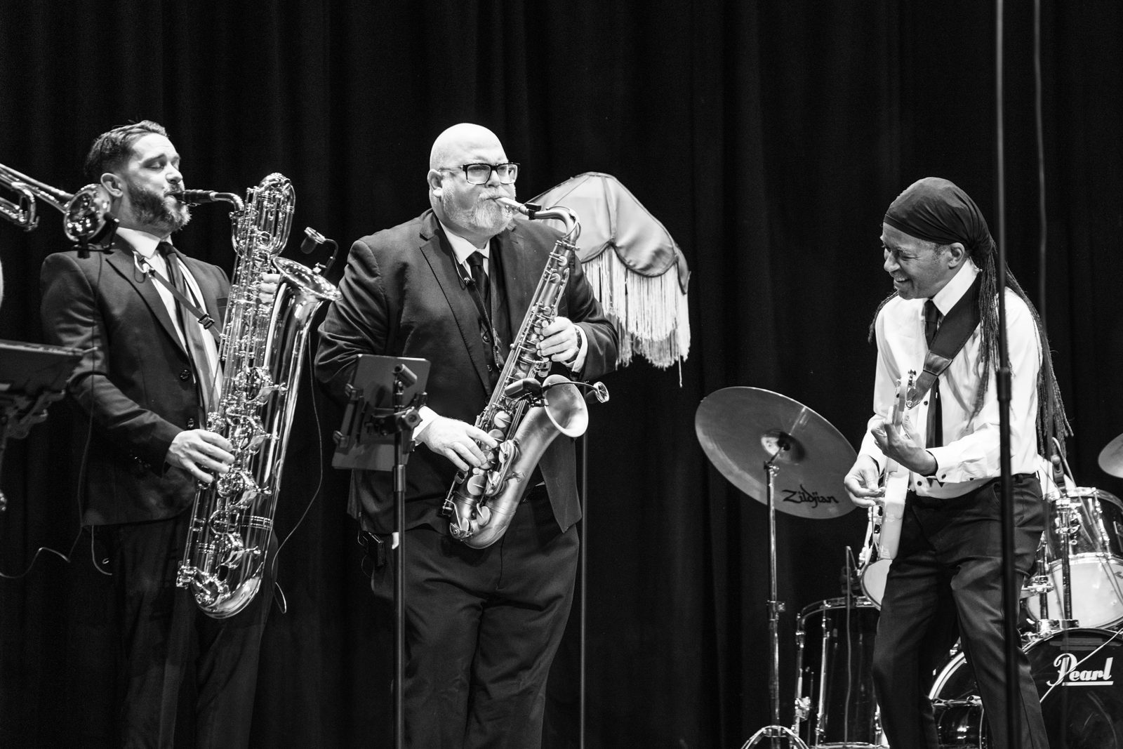 Black and white shot of the sax section performing live