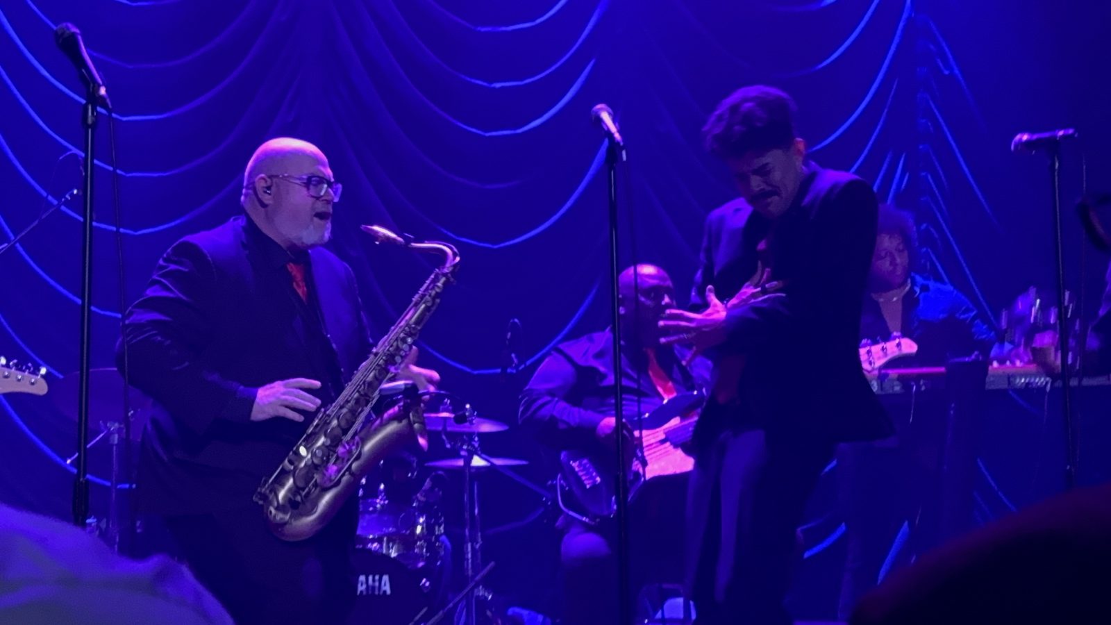 Steve Wilson on sax with the band under stage lights