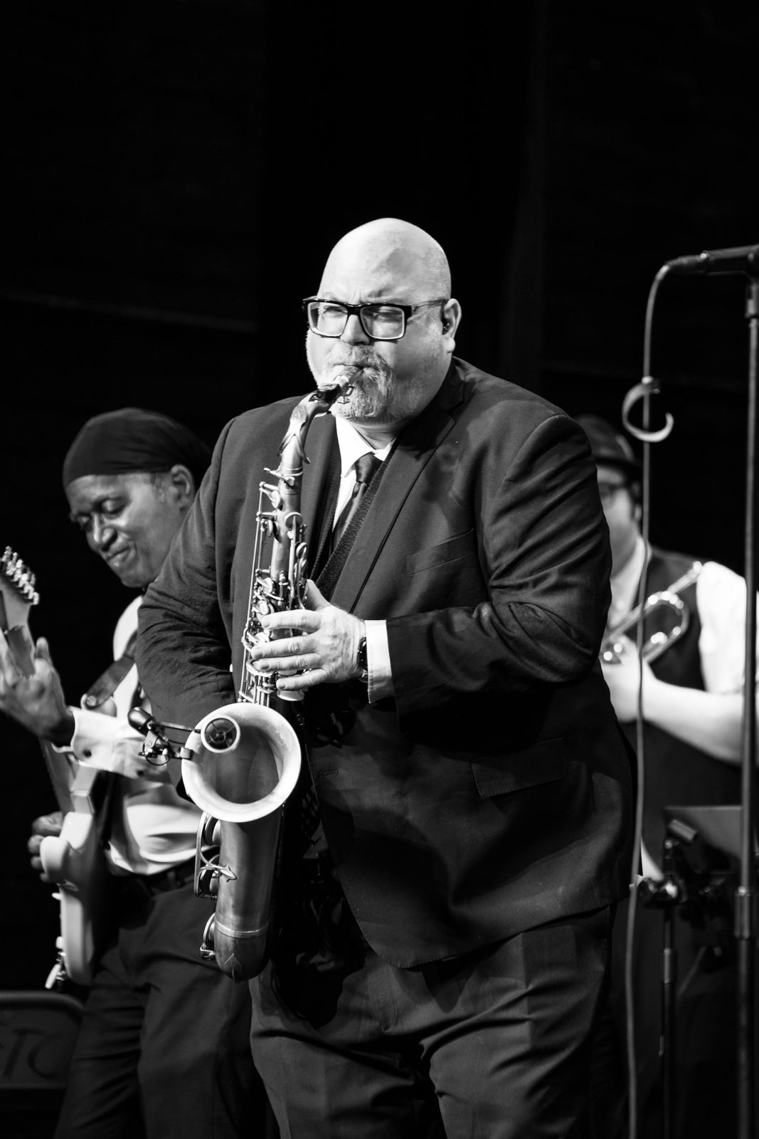 Steve Wilson playing saxophone in a black suit on stage